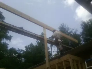 Carpenter setting a ridge beam over a new addition frame — Ice Dam Removal by Roofing Brothers in Sharpsburg