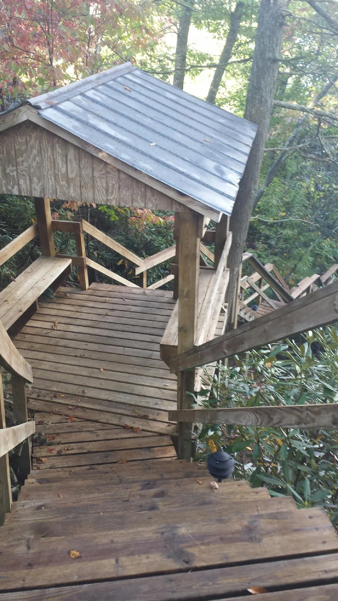 Metal roofed shelter over wooden steps on a wooded walkway — Skylight Repair & Installation work by our crew in Sharpsburg
